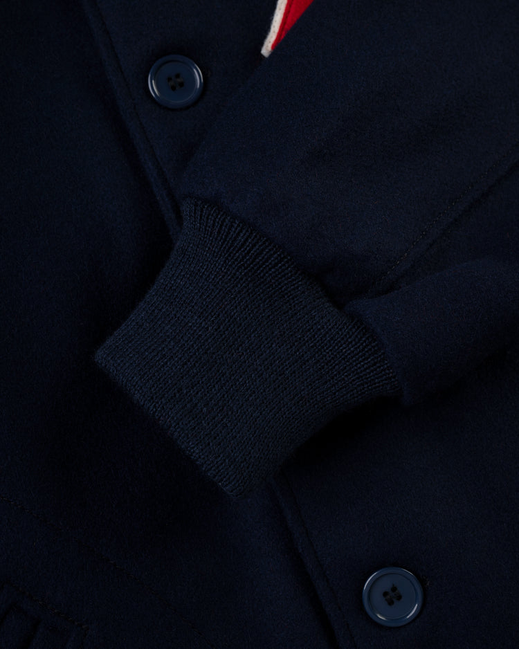 Close-up of the EFF Cincinnati Reds 1942 Authentic All Wool Varsity Jacket in navy blue, showing a ribbed knit cuff, dark buttons, and partial pocket; thick fabric evokes classic vintage baseball style.