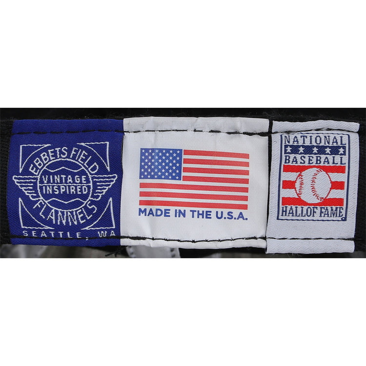 Three fabric labels: one reads Ebbets Field Flannels, the center shows a U.S. flag with MADE IN THE U.S.A., and the third honors the National Baseball Hall of Fame on this Bob Gibson Signature Series Ballcap.