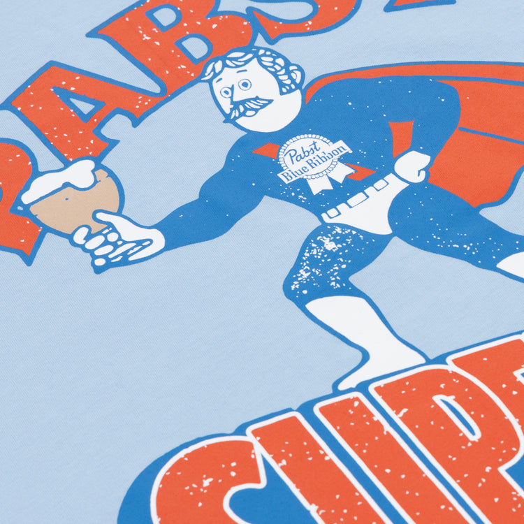 A cartoon superhero with a mustache wears the PBR EFF Vintage Beer T-Shirt by Ebbets Field Flannels, showing off the Pabst Blue Ribbon logo and holding a beer mug, with bold red and orange text celebrating classic Milwaukee brew.