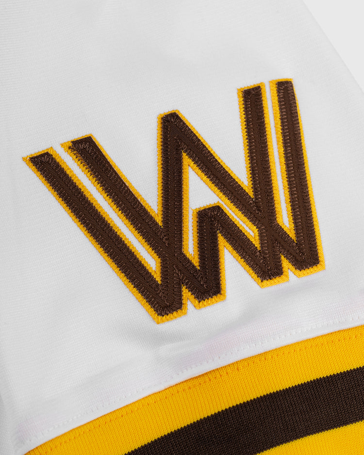 A close-up of the EFF Walla Walla Padres Mesh V-Neck Jersey shows a white fabric with a large brown and yellow embroidered W above matching horizontal stripes, echoing classic San Diego Padres colors.
