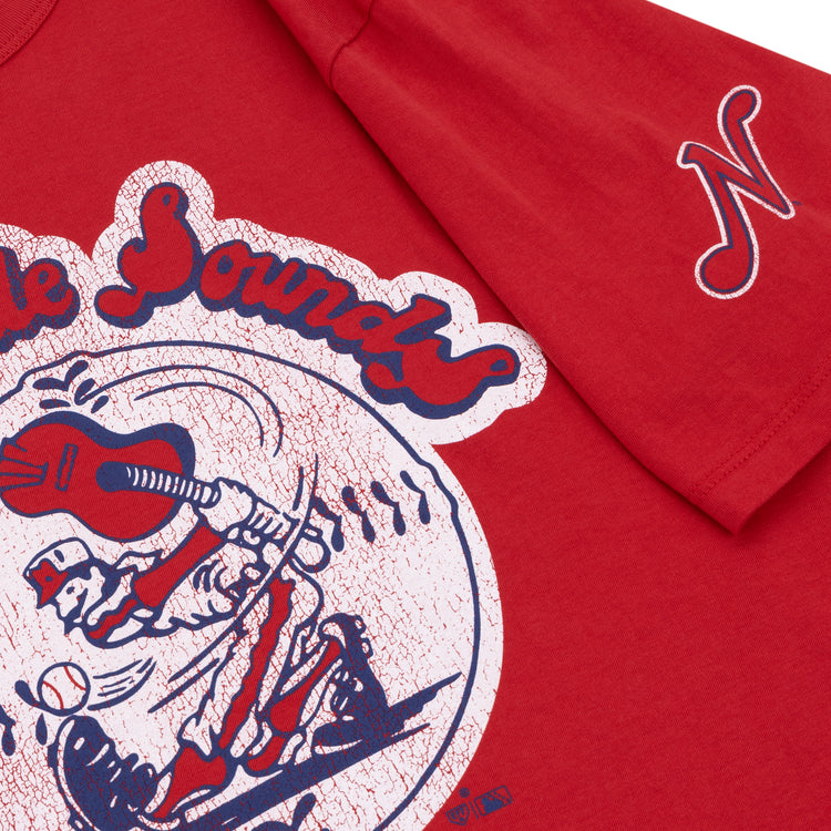 The Ebbets Field Flannels Nashville Sounds EFF MiLB Vintage T-Shirt features red premium cotton, a vintage baseball player graphic, The Sounds text above, and a white N logo on the sleeve.