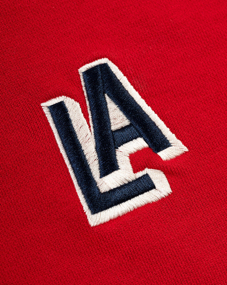 The Ebbets Field Los Angeles Angels (PCL) Heavyweight Cotton Terry Pullover Hoodie features bold white and navy LA embroidery on red, inspired by the vintage 1942 logo—a classic tribute to timeless baseball style.