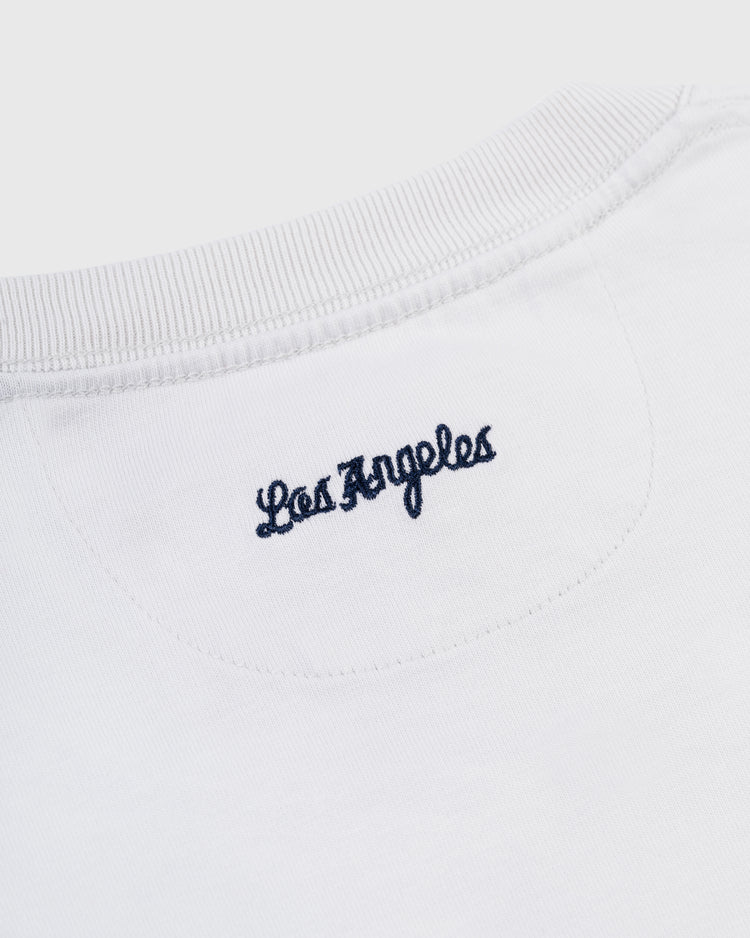 Close-up of the back neckline on the Ebbets Field Los Angeles Angels (PCL) Embroidered LA Short Sleeve Tee, showcasing Los Angeles in dark blue cursive inspired by the 1942 LA team logo.