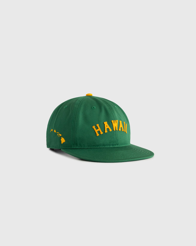 The Ebbets Field Hawaii Islanders (PCL) Cotton Twill Ballcap is a green vintage-style hat with yellow HAWAII embroidery and a yellow Hawaiian Islands outline, evoking classic baseball cap style against a light gray background.