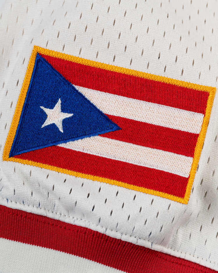 A close-up of the embroidered Puerto Rican flag patch on the Ebbets Field Santurce Cangrejeros Mesh V-Neck Jersey, featuring white perforated fabric and red-and-white stripes inspired by classic Puerto Rican baseball style.