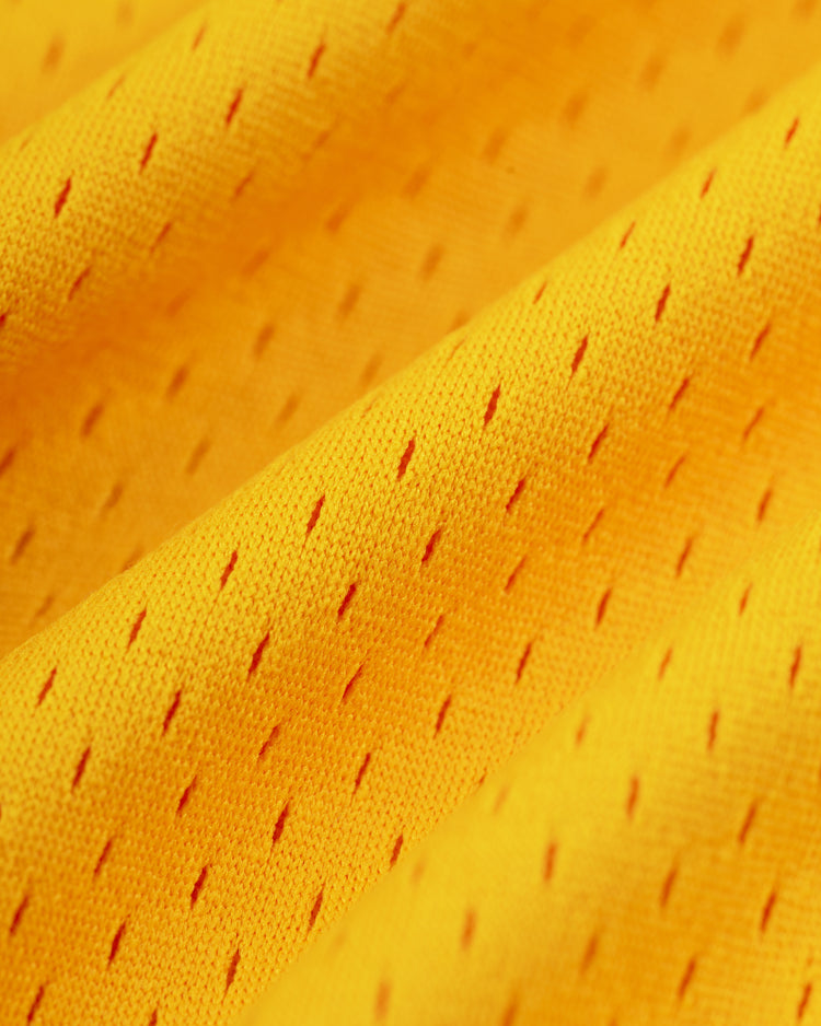 Close-up of the Ebbets Field Hawaii Islanders (PCL) Mesh V-Neck Jersey’s bright yellow mesh fabric with small, diamond-shaped holes and gentle folds—classic retro baseball jersey texture.