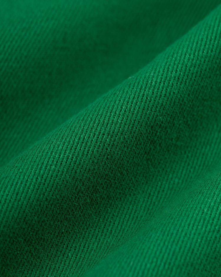 Close-up of Ebbets Field Hawaii Islanders (PCL) Cotton Twill Baseball Jersey fabric, showcasing its green color, visible texture, and distinctive diagonal weave pattern with soft folds and gentle shadows.