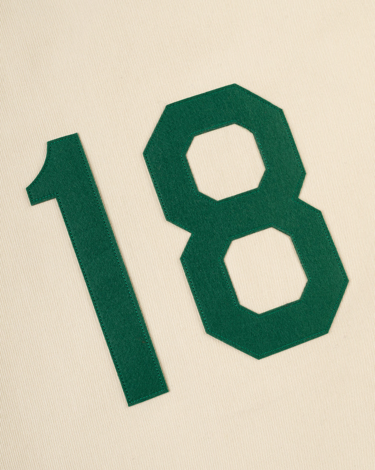 A bold green number 18 on a cream, textured background evokes the vintage Hawaii Islanders (PCL) Cotton Twill Baseball Jersey by Ebbets Field.