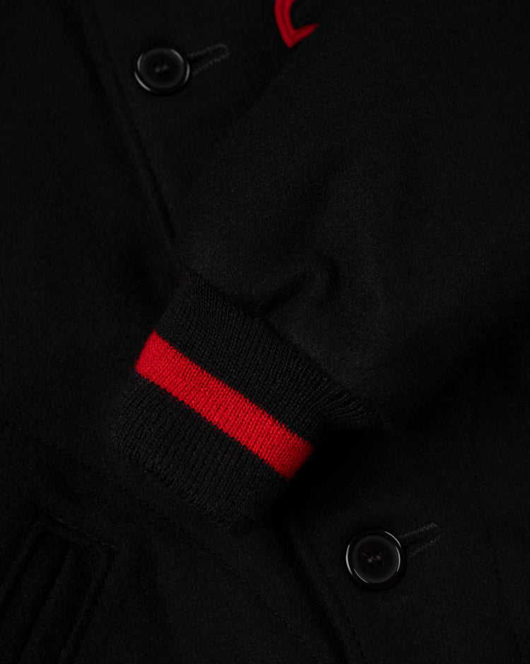 Close-up of the EFF Birmingham Black Barons 1940 Authentic All Wool Varsity Jacket sleeve, featuring a ribbed cuff with two red stripes, black buttons, and visible stitching details.