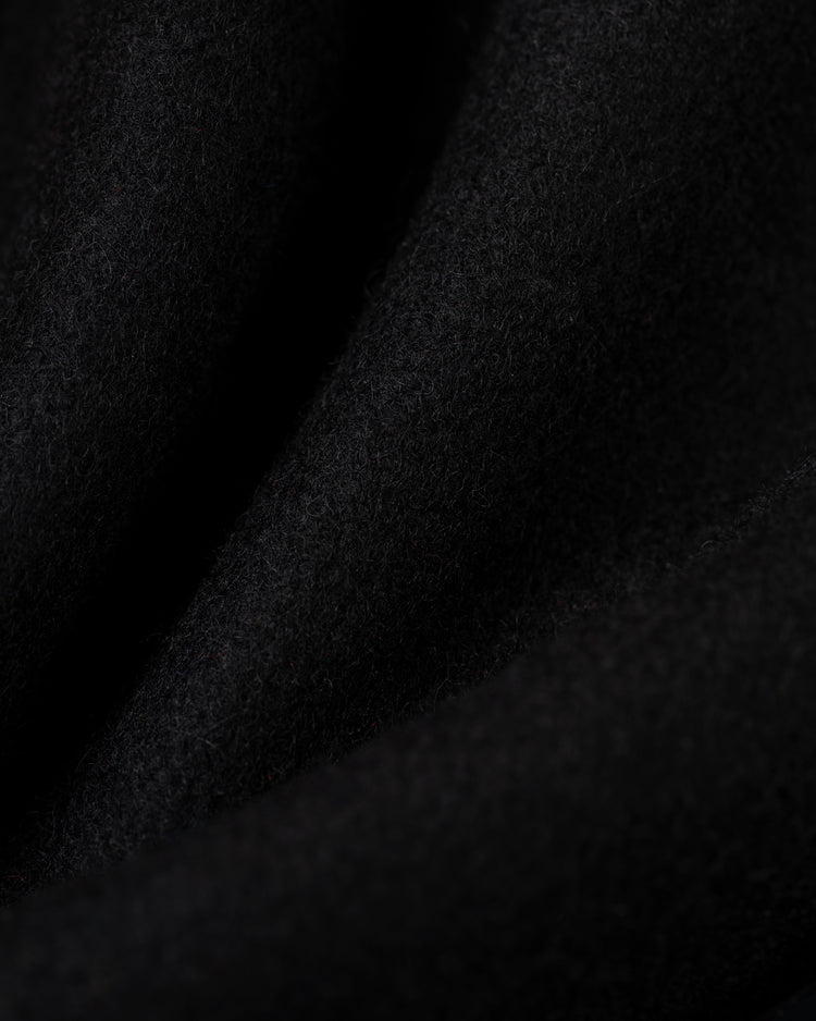 Close-up of soft, black wool fabric with a slightly fuzzy texture and gentle folds from the EFF Birmingham Black Barons 1940 Authentic All Wool Varsity Jacket, creating subtle shadows and highlights.