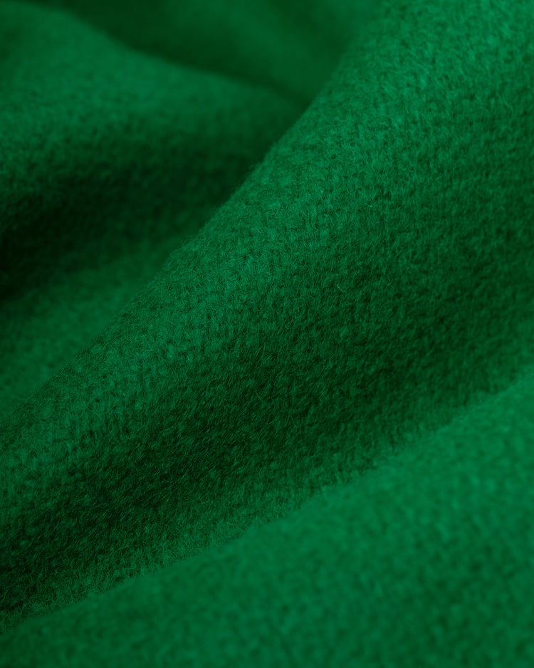Close-up of soft, green all-wool fabric with a fuzzy texture, evoking the EFF Brooklyn Dodgers 1937 Authentic Varsity Jacket. The material is draped in gentle folds, casting subtle shadows and highlights on its surface.