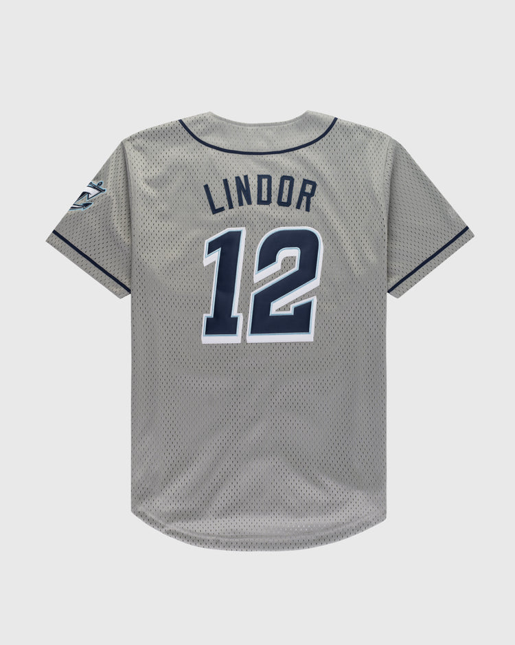 The Ebbets Field FRANCISCO LINDOR BUTTON UP MESH JERSEY GRY features gray mesh with navy trim, Lindors name and number 12 in bold navy and white on the back, plus a logo patch on the right sleeve.