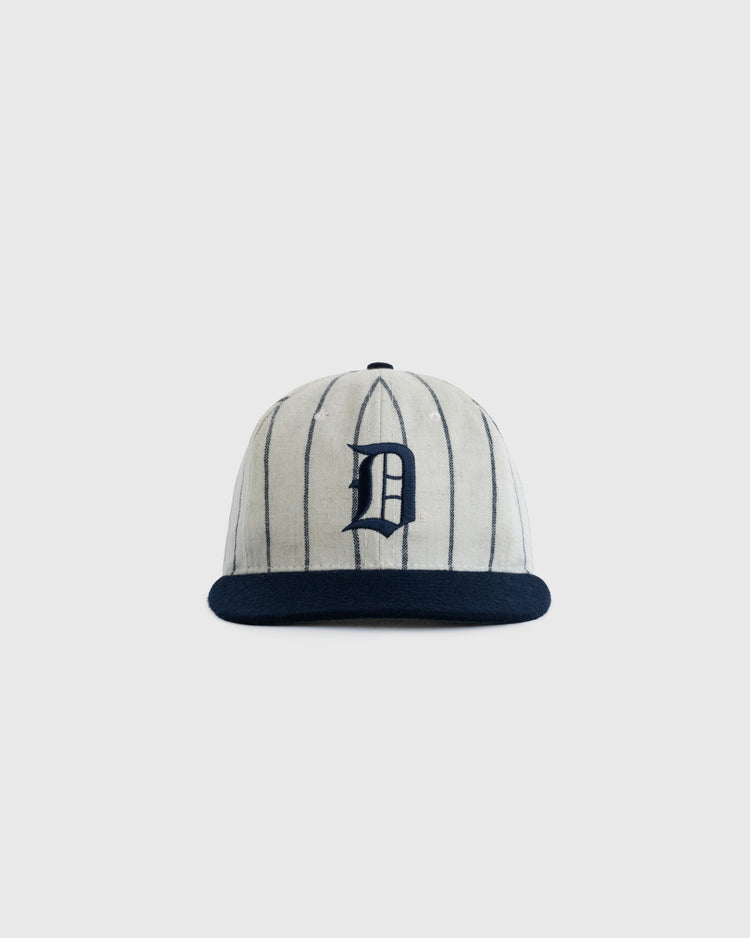 The EFF Duke University Pinstripe Authentic Wool Ballcap features vintage vertical pinstripes, a navy brim, and a bold navy D on the front, inspired by the 1968 Duke ballcap. Shown against a plain light gray background.