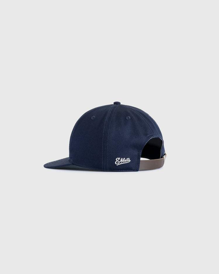 The Ebbets Field Flannels Felt E Cotton Twill Ballcap in navy features a curved brim, side white felt E, and an adjustable brown leather strap—ideal for daily wear—shown on a plain light gray background.