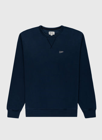 The Ebbets Chest Logo Heavyweight Cotton Terry Crewneck by Ebbets Field Flannels is a navy blue long-sleeve sweatshirt with ribbed cuffs and hem, plus a small embroidered logo on the left chest, shown on a light gray background.