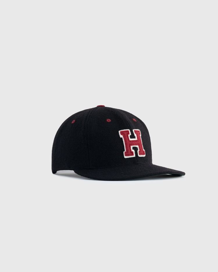 The Harvard University Crimson H Authentic Wool Ballcap by EFF features a black cap with a red H on the front, capturing classic Ivy League style and shown on a light gray background.