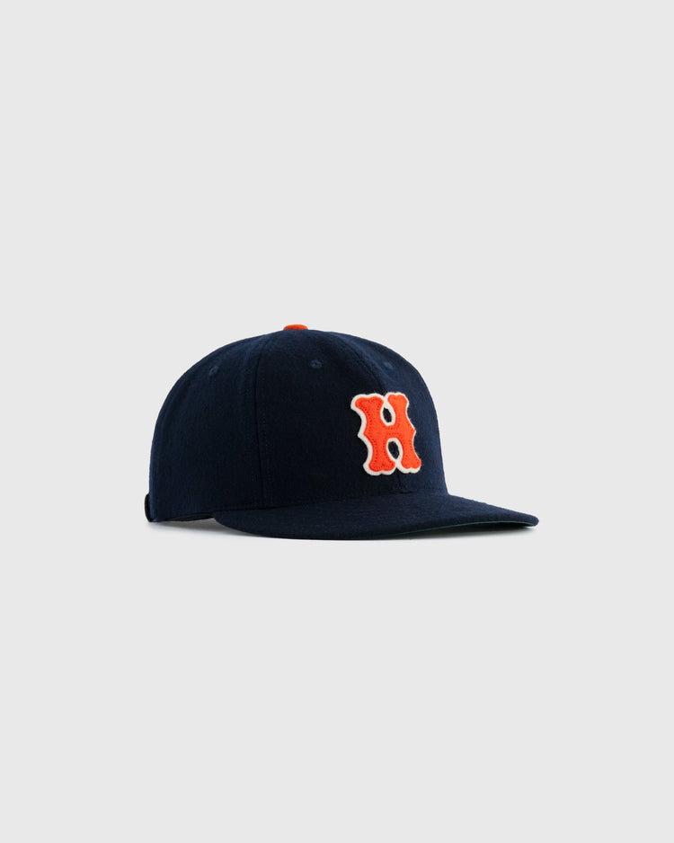 The Ebbets Field Flannels Hiroshima Carp 1958 Authentic Wool Ballcap is a navy cap with a bold orange “H” outlined in white on the front, shown on a plain light gray background.