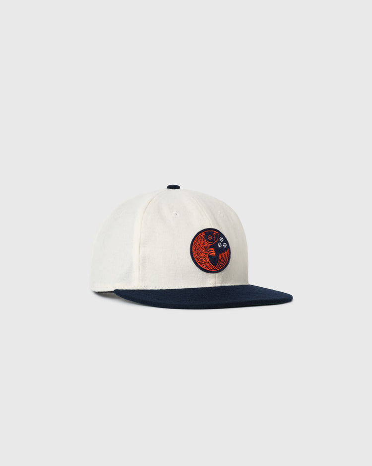 The EFF Hiroshima Carp Off White Wool Ballcap features a navy brim and a round orange and navy embroidered Carp patch on the front panel, shown against a plain light gray background.