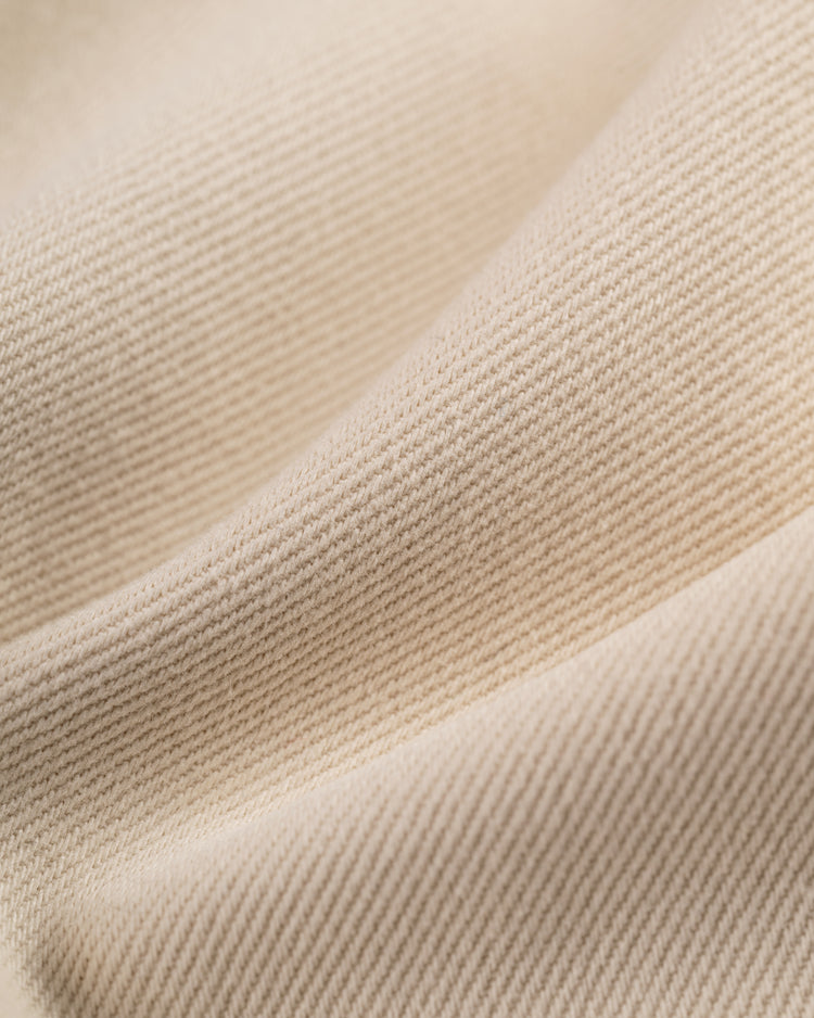 A close-up of soft, beige cotton twill with gentle folds mirrors the fine weave and subtle diagonal texture of the Ebbets Field Flannels Homestead Grays Cotton Twill Baseball Jersey.