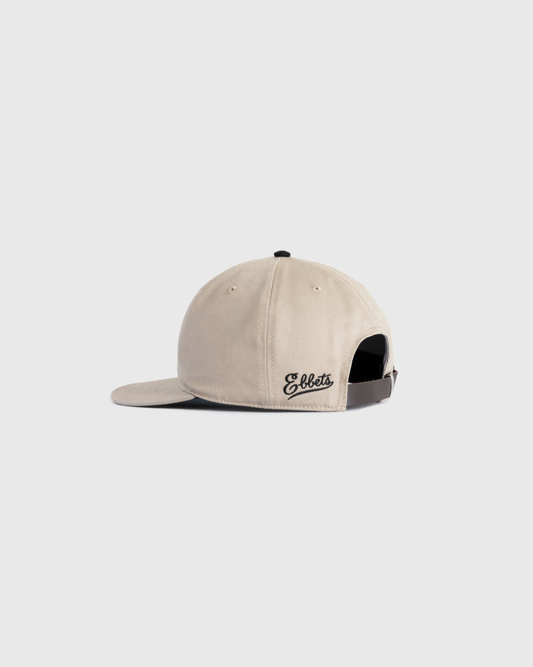 The Ebbets Field Flannels Homestead Grays Embroidered G Cotton Twill Ballcap is beige with an adjustable black strap and Ebbets embroidered in black on the left side, inspired by classic styles, shown against a light gray background.