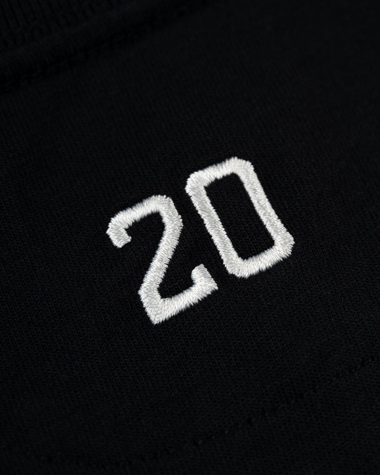 Close-up of the number 20 embroidered in white on black fabric from the Ebbets Field Flannels Homestead Grays G Short Sleeve Tee, honoring Josh Gibson, a Negro Leagues legend.