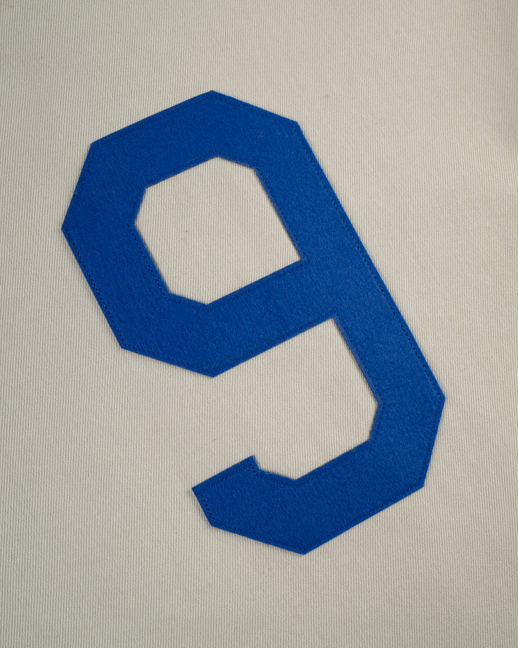 A bold blue number 9 stands out on the white, textured fabric of the Ebbets Field Montreal Royals Cotton Twill Baseball Jersey, evoking classic team style.