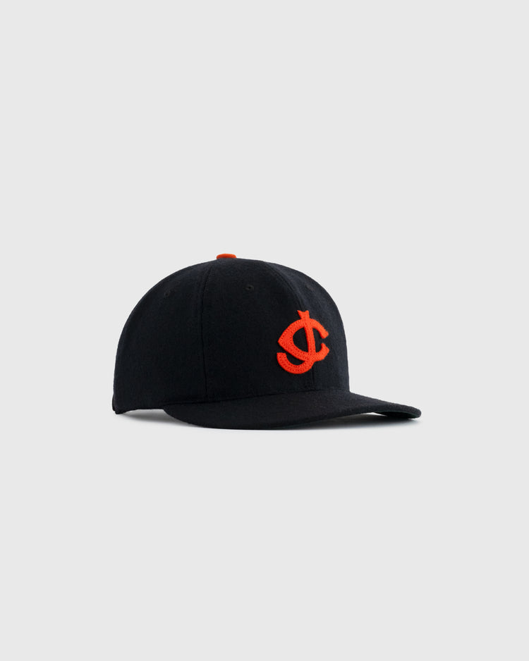 The EFF Jersey City Giants 1950 Authentic Wool Ballcap is a black cap with an orange embroidered interlocking J and C logo on the front, inspired by the 1950 team, shown against a plain light gray background.