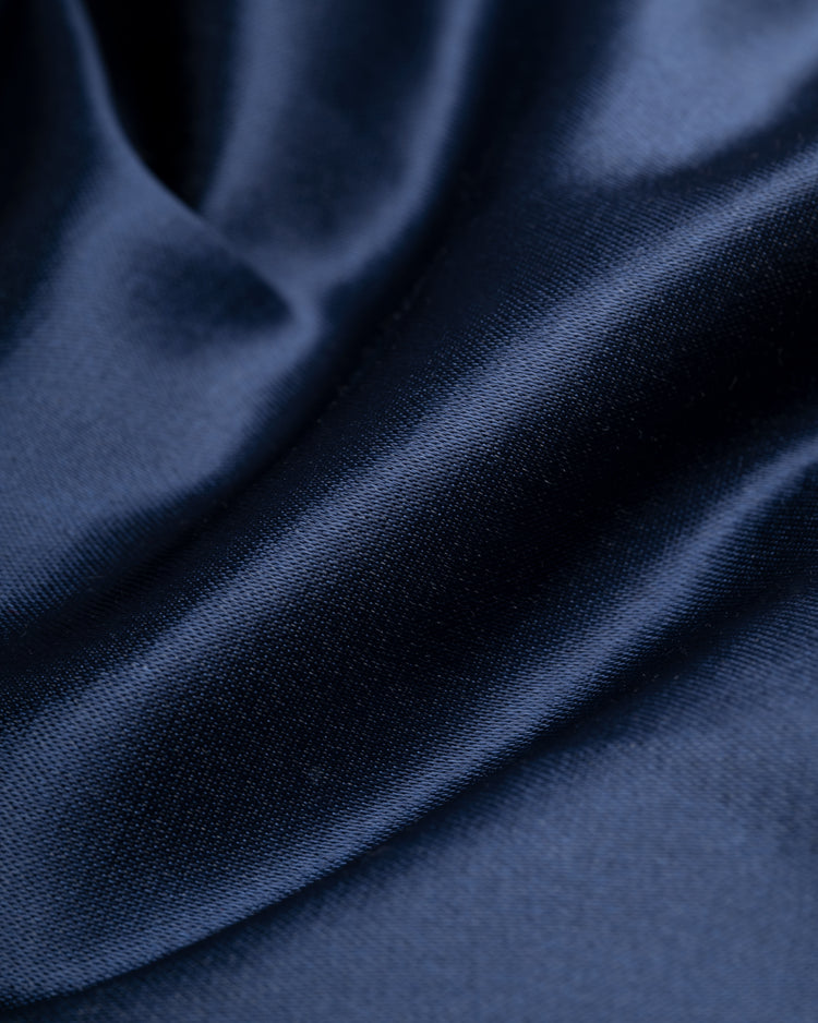 Close-up of smooth, dark navy blue satin fabric with soft folds and a shiny surface, featured on the EFF Kansas City Athletics 1960 Authentic All Satin Varsity Jacket.