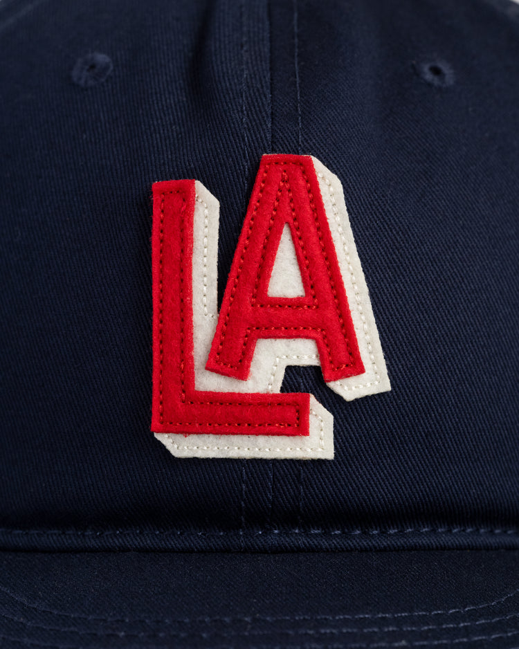 A close-up of the Ebbets Field Los Angeles Angels (PCL) 1942 Logo Cotton Twill Ballcap, featuring a navy blue cap with a red and white embroidered LA logo inspired by the vintage minor league teams original design.