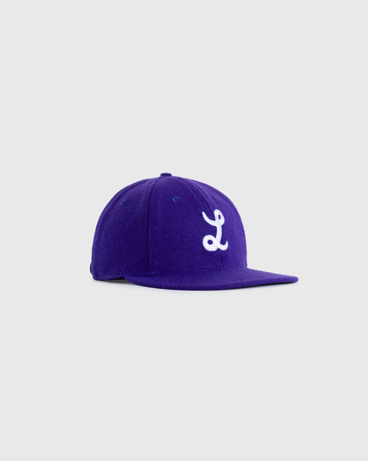 The EFF Louisiana State University 1957 Authentic Wool Ballcap features a flat brim and white embroidered L on purple wool, inspired by vintage LSU hats, shown against a light gray background.