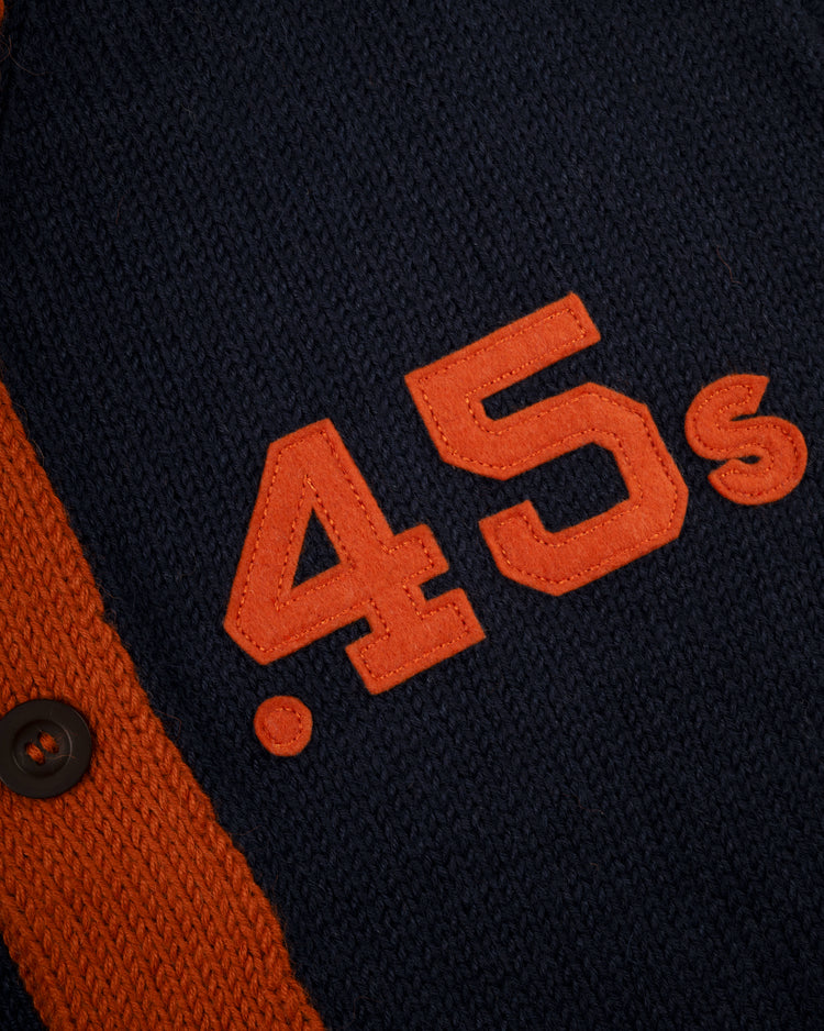 Close-up of the Ebbets Field Flannels Houston Colt .45s 1962-64 Wool Shawl Collar Sweater: navy blue with bold orange 45, small s, and an orange stripe with black button—ideal for fans of replica on-field baseball sweaters.