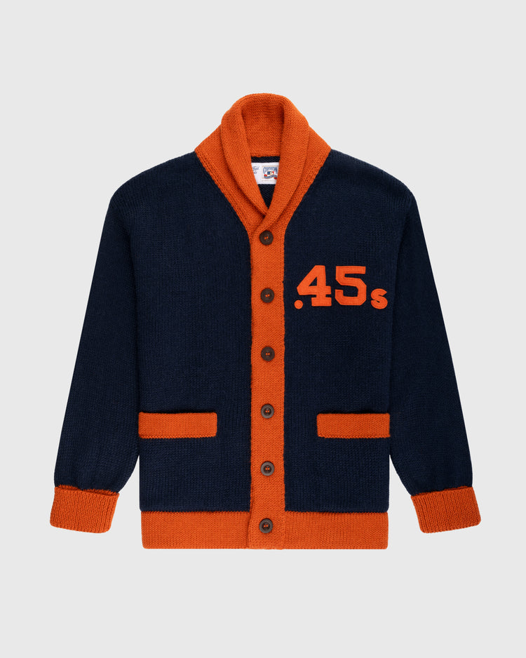 The Ebbets Field Flannels Houston Colt .45s 1962-64 Wool Shawl Collar Sweater is navy with orange trim, collar, cuffs, and pockets. Inspired by vintage baseball sweaters, it has brown buttons and large orange .45s on the left chest.