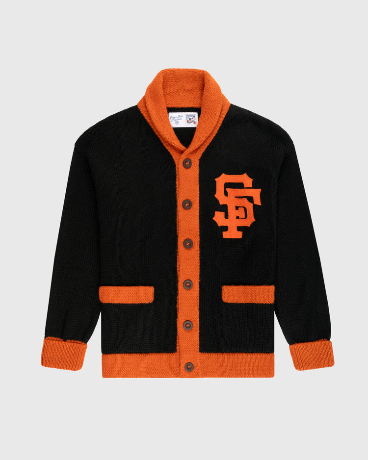 The Ebbets Field Flannels San Francisco Giants 1958-1972 Wool Shawl Collar Sweater features black wool with orange trim, cuffs, and pockets, large orange buttons, a bold SF chest logo, and replicates the classic on-field style.