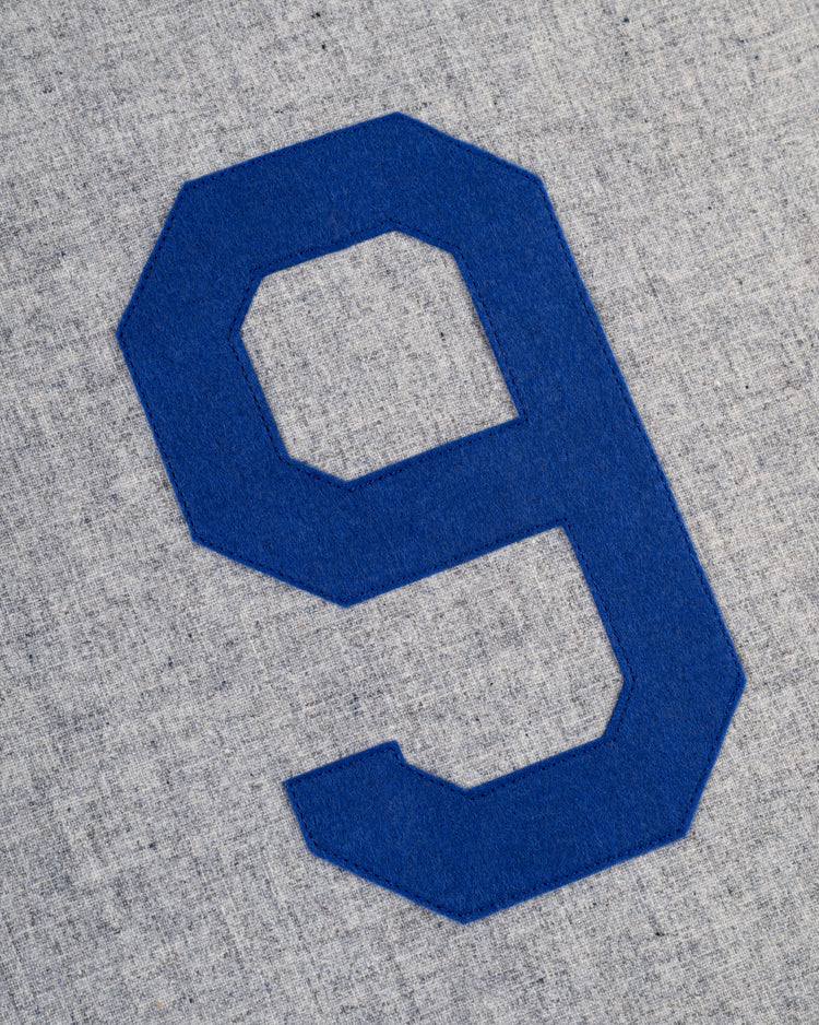 A large, blue number 9 appears on light gray textured fabric, evoking the classic Montreal Royals look of the 1946 Ebbets Field Authentic Wool Road Baseball Jersey.