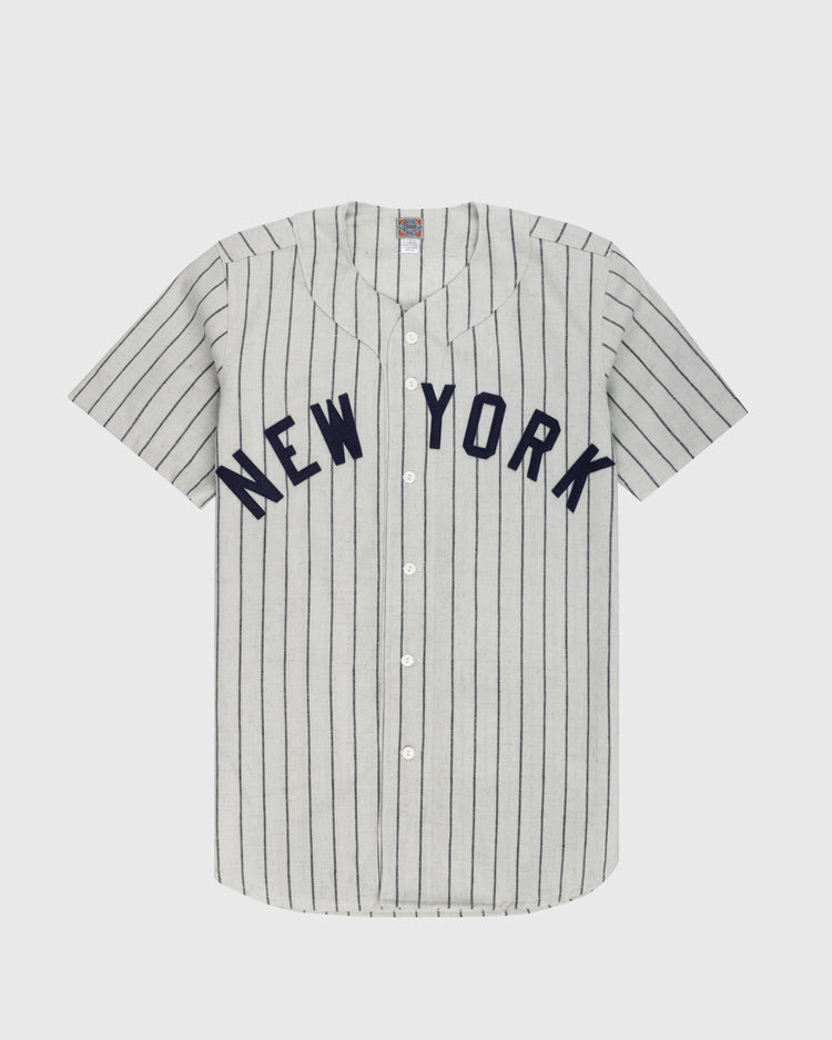 The Ebbets Field New York Black Yankees 1942 Authentic Wool Home Baseball Jersey features gray wool flannel with thin navy stripes, bold NEW YORK on the chest, white front buttons, and short sleeves inspired by the original Negro Leagues jersey.