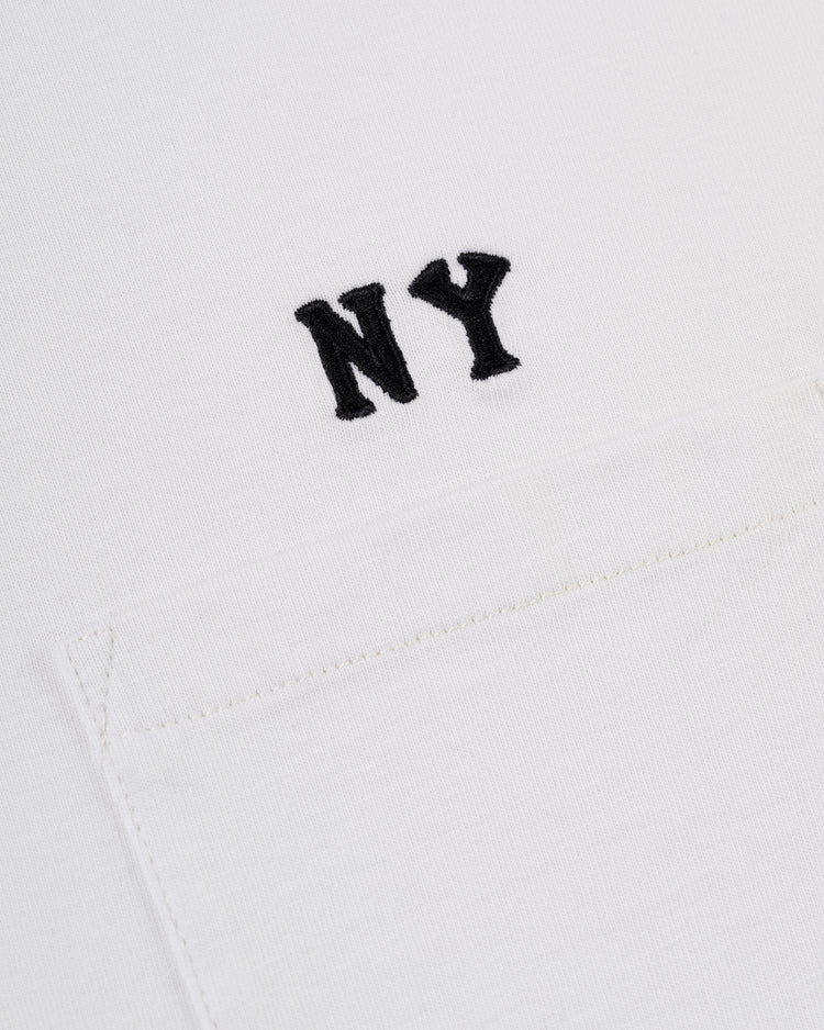 Close-up of the Ebbets Field New York Black Yankees Embroidered NY Short Sleeve Tee, showcasing white fabric with a small pocket and black NY embroidery above it, inspired by the Black Yankees.