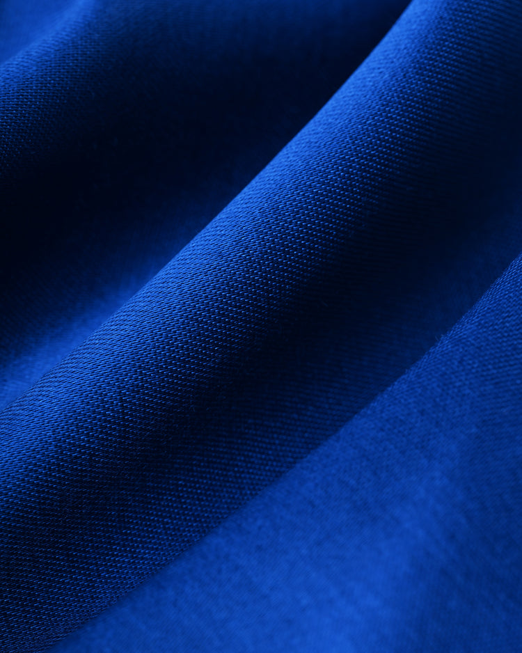 Close-up of smooth, vibrant blue satin fabric with gentle folds and fine weave, resembling the Chicago Cubs 1946 Satin Windbreaker Jacket by EFF.