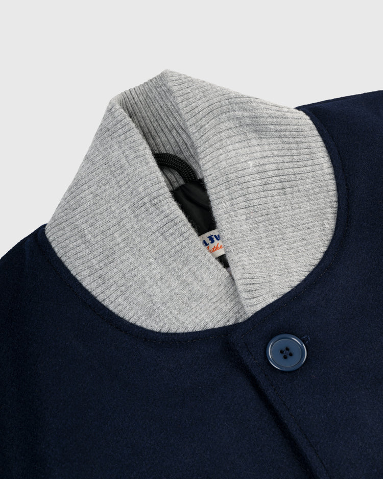 Close-up of the EFF New York Yankees 1936 Authentic All Wool Varsity Jacket in navy blue with a gray ribbed collar, dark blue button, and partially visible labelâa faithful reproduction of the classic on-field jacket.