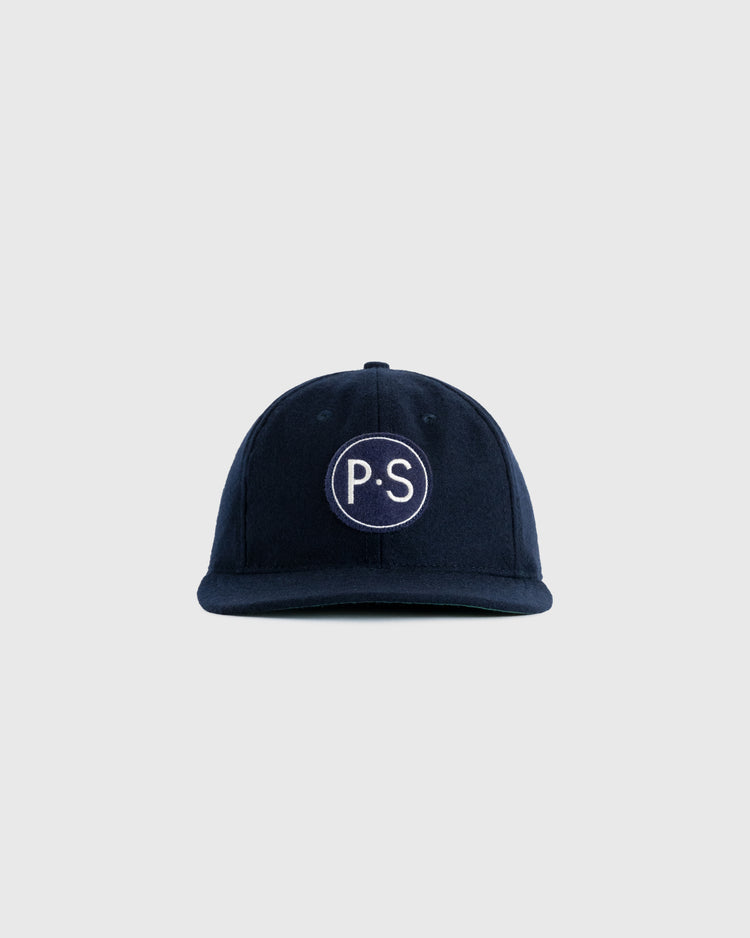 The EFF Penn State University 1963 Authentic Wool Ballcap is a navy cap with a curved brim and a white embroidered circle featuring P.S, inspired by vintage Nittany Lions logo style. Plain light gray background.