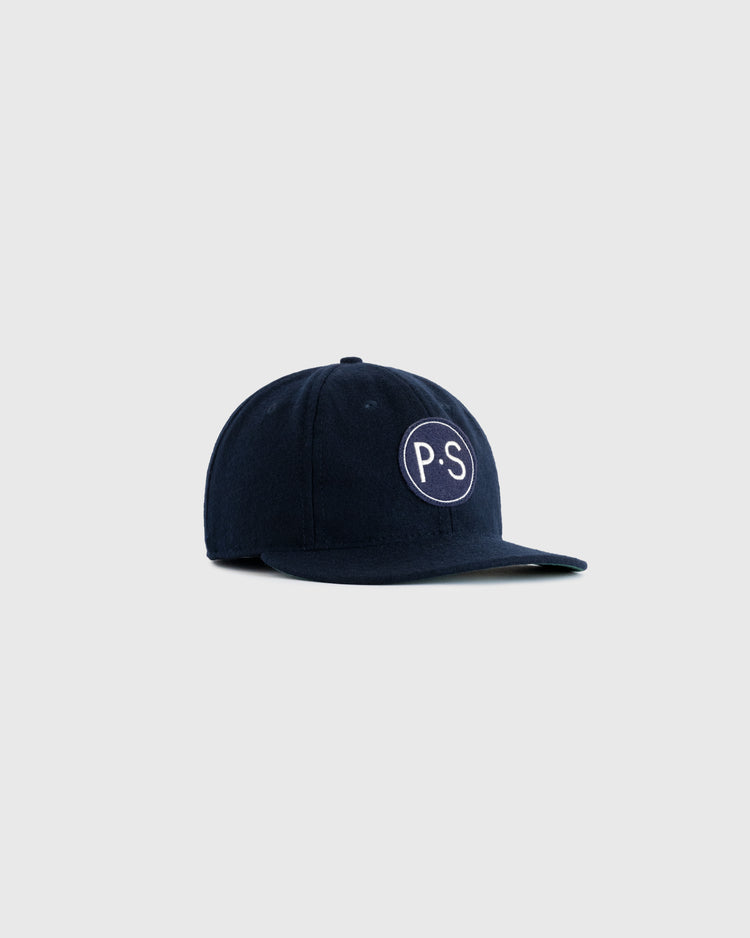 The EFF Penn State University 1963 Authentic Wool Ballcap is a navy blue cap with a white-bordered patch showing P.S in white, inspired by vintage 1963 PSU logos, displayed on a plain light gray background.