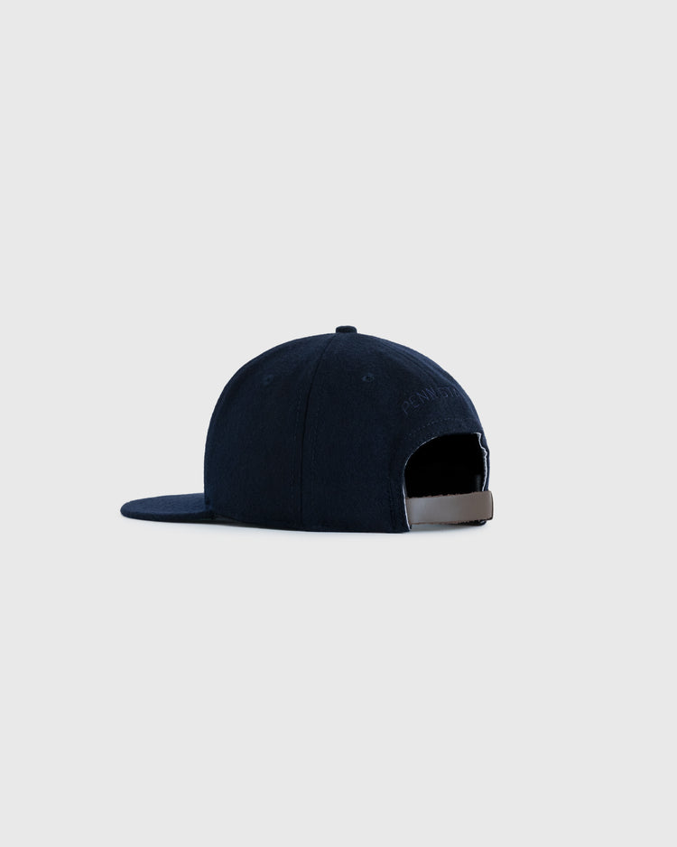 A navy blue EFF Penn State University 1963 Authentic Wool Ballcap is shown from the back on a light gray background, featuring a curved brim, adjustable strap with metal clasp, and vintage-inspired Nittany Lions logo style.