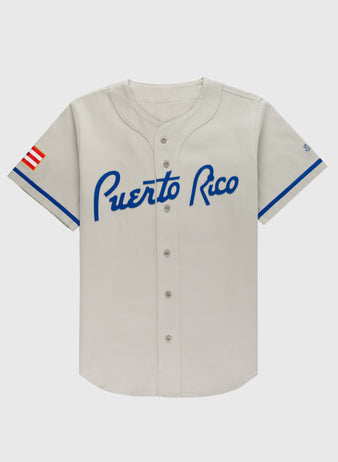 The Ebbets Field Puerto Rico 1958 National Team Cotton Twill Baseball Jersey is light gray with blue trim, “Puerto Rico” in blue script on the chest, and a red, white, and blue Puerto Rican flag patch on the left sleeve.