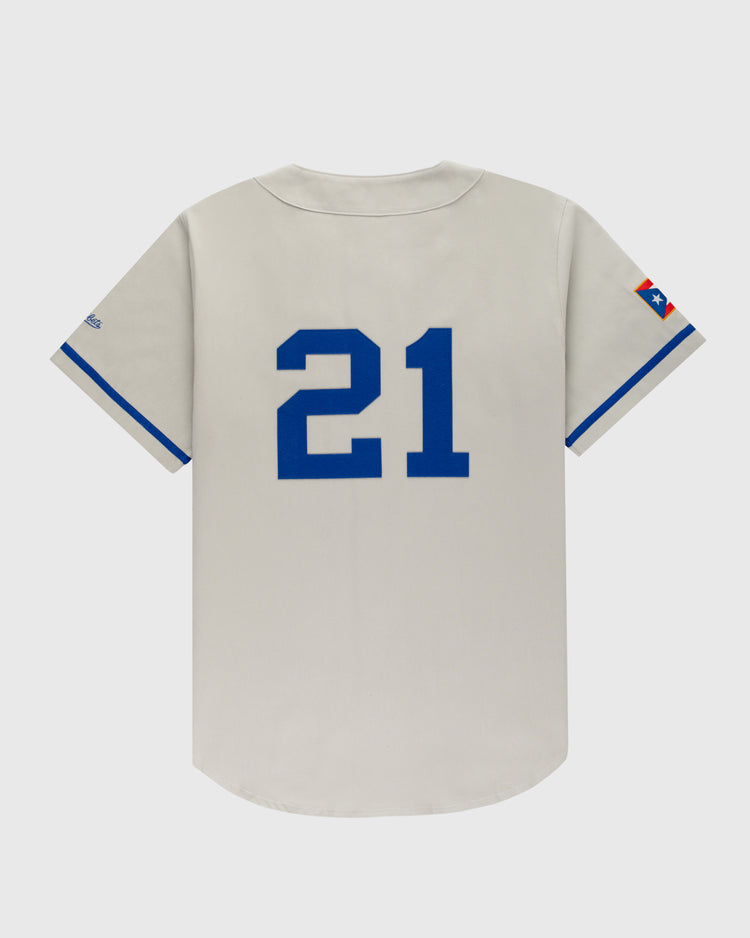 The Ebbets Field Puerto Rico 1958 National Team Cotton Twill Baseball Jersey is gray with blue sleeve trim, a large blue number 21 on the back, and a star patch on the left sleeve, inspired by the iconic 1958 team.