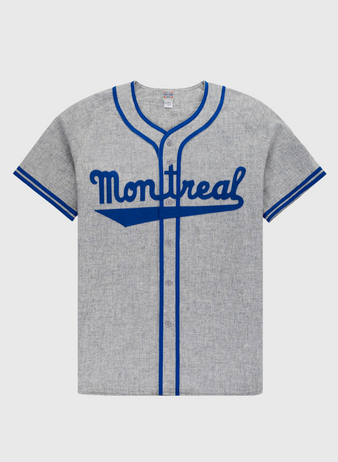 The Ebbets Field Montreal Royals 1946 Authentic Wool Road Baseball Jersey features heather gray wool, blue trim, Montreal script on the chest, a button-down front, and short sleeves—replicating Jackie Robinson’s iconic road jersey.