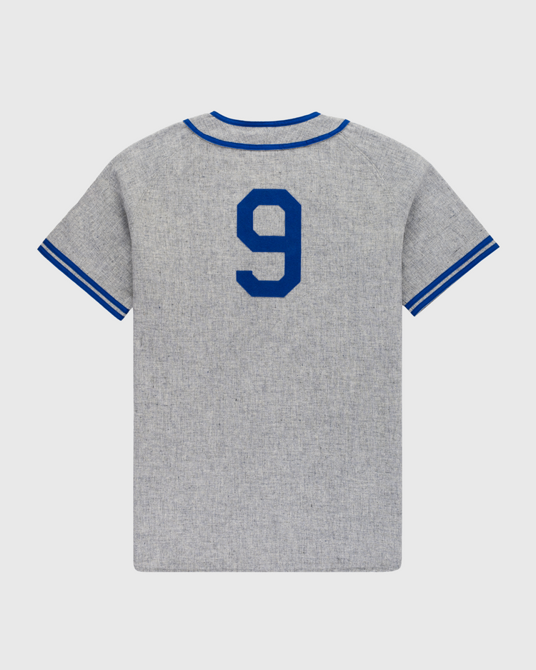 The Ebbets Field Montreal Royals 1946 Authentic Wool Road Baseball Jersey features gray wool, blue collar and sleeve trim, and a large blue number 9 on the back, inspired by Jackie Robinson’s iconic jersey.
