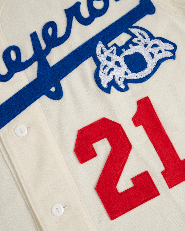 Close-up of the Ebbets Field Santurce Cangrejeros 1954 Authentic Wool Home Baseball Jersey in vintage cream, with large red 21, blue script lettering, white and blue patch, and white buttons.