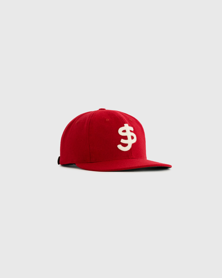 The Ebbets Field Flannels San Juan Senadores 1947 Authentic Wool Ballcap features a red wool build with a white raised embroidered interlocked “S” and “F” on the front, shown on a plain light gray background.