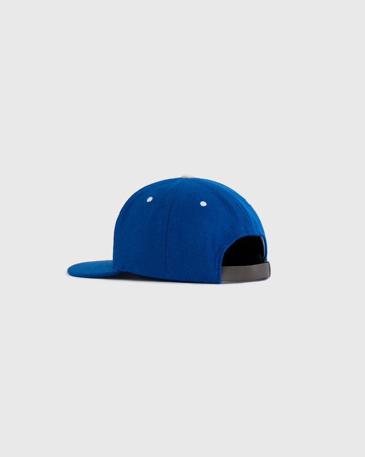The EFF Santurce Cangrejeros 1954 Authentic Wool Ballcap is shown from the back, in blue with a black adjustable strap and white eyelets, set against a plain light grey background.