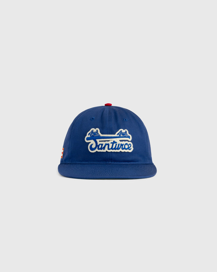 The Ebbets Field Santurce Cangrejeros Cotton Twill Ballcap features “Santurce” in white script, two blue crab illustrations above the text, a red top button, and a light gray background—ideal for Puerto Rican baseball fans.