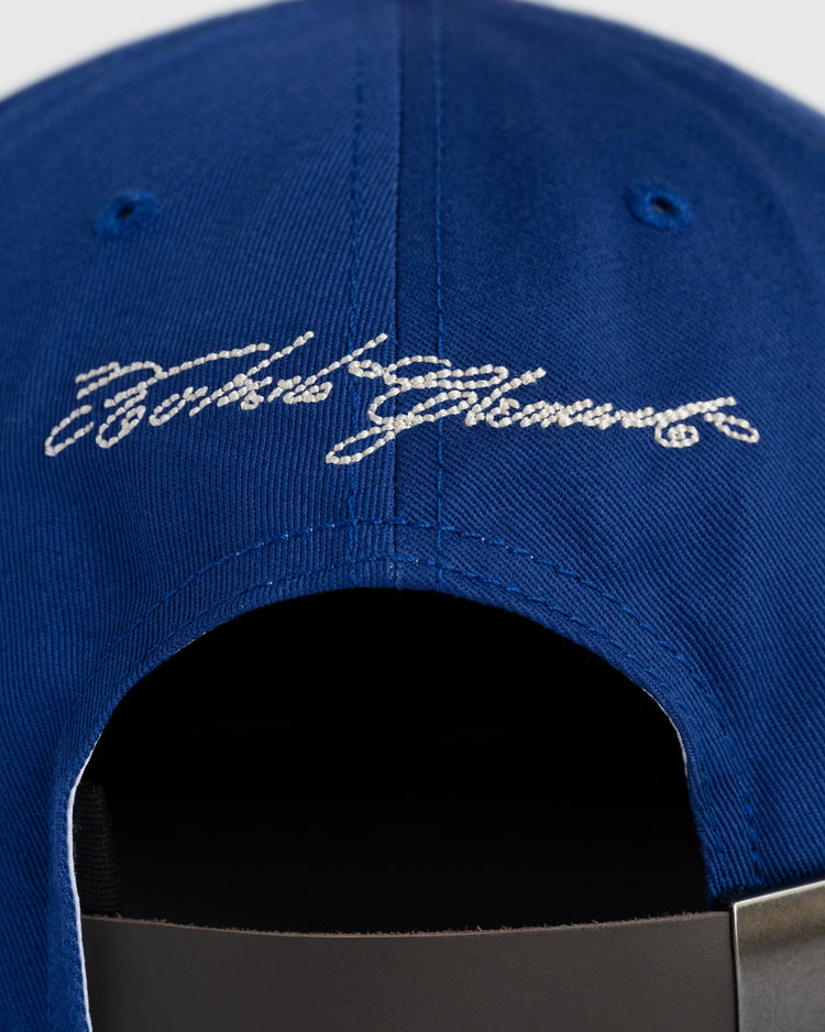 Close-up of the back of the Ebbets Field Santurce Cangrejeros Cotton Twill Ballcap, inspired by Puerto Rican baseball, with white cursive embroidery and an adjustable strap with a metal buckle.